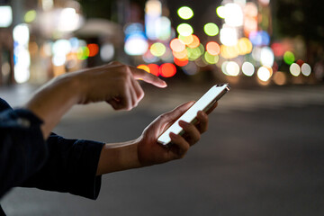 道の上でスマートフォンを開く人