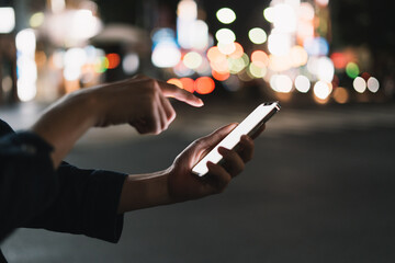 道の上でスマートフォンを開く人