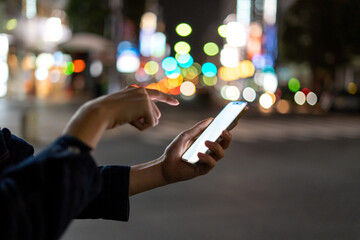 道の上でスマートフォンを開く人