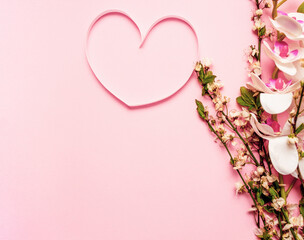 Spring layout with flower and heart made of pink ribbon on purple background. Spring concept