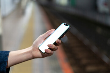 道の上でスマートフォンを開く人