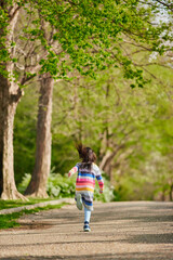 Fototapeta na wymiar 春の公園で元気で走って遊んでいる可愛い子供の様子