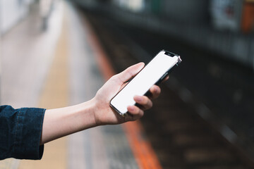 道の上でスマートフォンを開く人