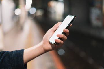 道の上でスマートフォンを開く人