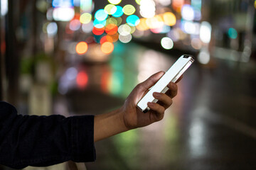 道の上でスマートフォンを開く人