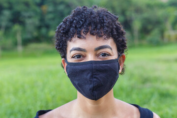 Jovem mulher brasileira posa para fotografia com máscara de proteção contra Covid 19, em Guarani, estado de Minas Gerais, Brasil