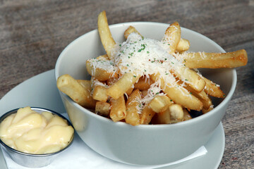Cheese on top of french fries with white sauce.