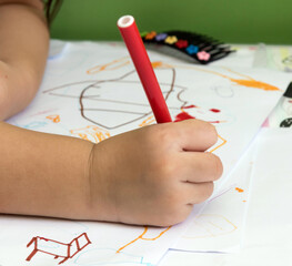 A girl hold red magic pen on right hand for writing.
