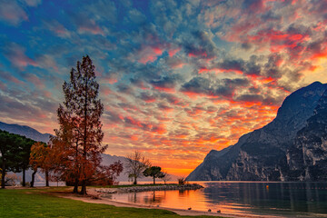 View of the beautiful Lake Garda surrounded by mountains, Scenic view of sunset at Lake Garda in the evening with the beautiful sunset colors, italy