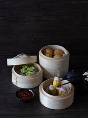 Assorted Dim Sum on Dark Background with copy space. Dim Sum Dark Food Photography. Shumai (Prawn...