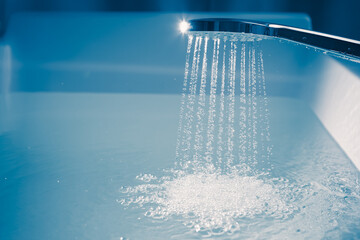 Naklejka na ściany i meble shower filling a bathtub with water stream