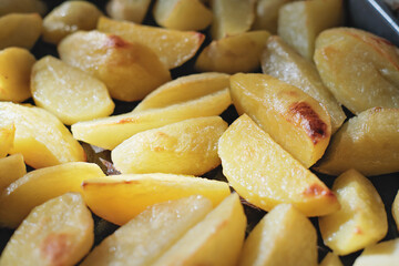 Crispy oven baked potatoes. Delicious golden roasted potatoes for home dinner just out of the oven. family weekend dinner, close up
