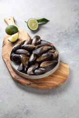 Shellfish raw Mussels on gray plate, gray background. Shellfish seafood. Top view.