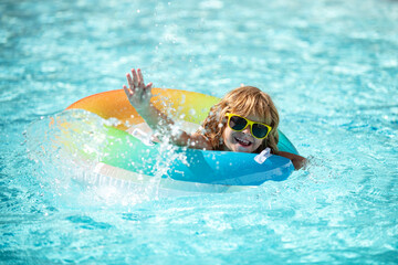 Kid in swimming pool. Boy at aquapark. Summer weekend. Summertime vacation.
