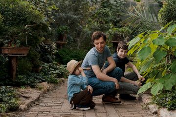 Adventurous family inspecting tropical gallery in Botanical garden. Local travel