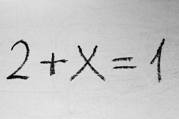 Tricky math equation on the white chalkboard via black chalk. Handwriting simple mathematical equations. Back to school concept