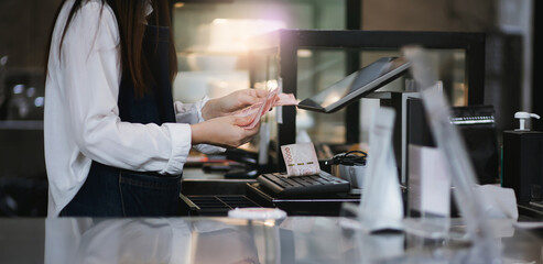 Cropped shot of young asian woman working in small business and recive money from customers