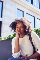 young pretty african girl posing cheerful on city background, lifestyle outdoor people concept