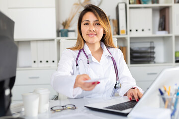 Confident latina woman physician consulting female at clinic, giving prescription