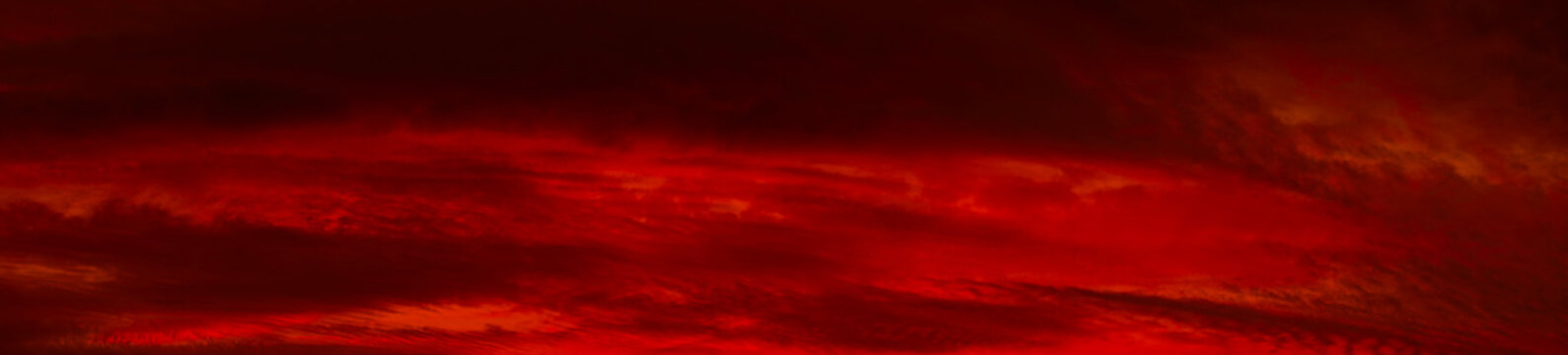 Red orange sunset background. Dramatic sky with clouds. Abstract red background with copy space for design. Wide banner. Panorama.