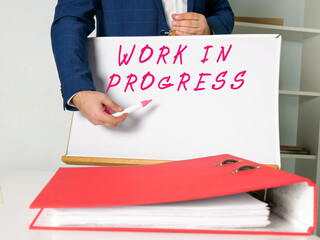 Business concept about WORK IN PROGRESS with sign on the piece of paper.