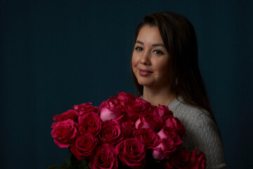 Young woman holding bouquet of roses flowers