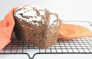 Homemade gluten free buckwheat bread with various seeds on a rack. fresh baked low carb bread covered with napkin