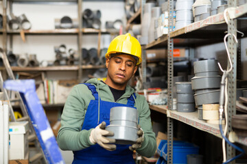 Confident latin american handyman man choosing materials for overhauls in building materials store