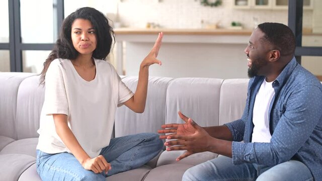 Multiracial couple is arguing at home. Angry young spouses screaming and misunderstanding to each other, African-American couple has relationships problem
