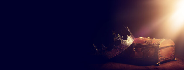low key image of beautiful queen or king crown over gold treasure chest. vintage filtered. fantasy...