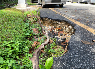Close up of a big pothole at the edge of the road
