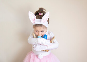 A cute little girl in an Easter bunny costume is trying to protect her egg basket. Selective Focus hands