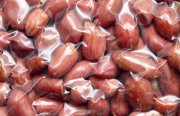 Close up of peanut nuts in a plastic bag as a background. Macro