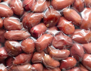 Close up of peanut nuts in a plastic bag as a background. Macro