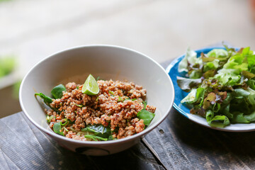 Pork chops in a bowl of noodles look delicious. There is a lemon on top, dried noodle soup with minced pork. Food of Thailand