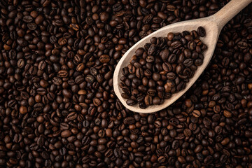 Coffee beans with wooden spoon background or texture.