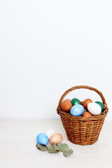 colorful eggs in a basket on a light background and church traditions foundations