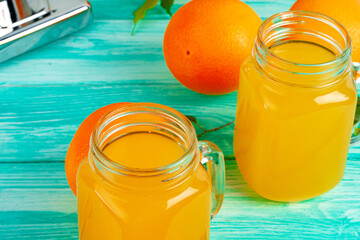 Glass with orange juice on green wooden table