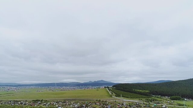 The camera takes pictures from the air of a small provincial town, the sky and the hills nearby. Very beautiful landscape