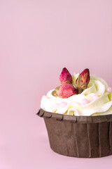 cupcakes with vanilla cream decorated with roses on pink background with  copy space for text .Vertical . Valentines and wedding  concept ,card .