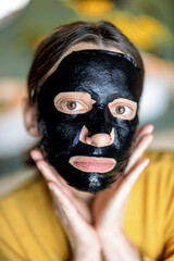 Woman with cleansing black mask on her face