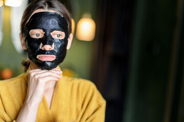 Woman with cleansing black mask on her face