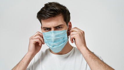 Young serious man wearing medical mask
