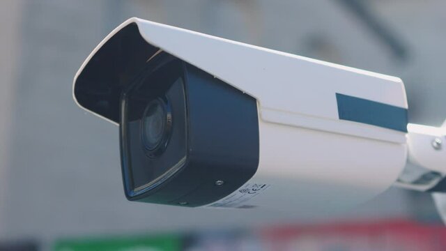 At sunlight security camera moving recording outside a building. CCTV surveillance. Privacy, urban, protection, house, system, control, secure, view, safe, video. Slow motion