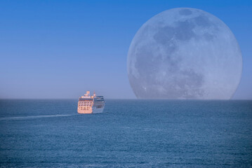 A cruise ship sailing away under the light of a full moon