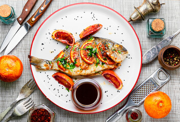 Baked dorada in orange sauce.