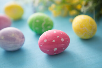 Easter eggs decoration with flowers on blue wooden table
