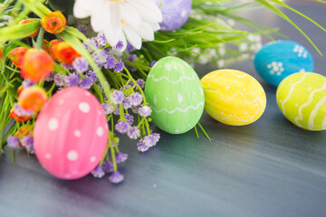 Colorful easter decoration with and flowers on gray wooden table. Top view
