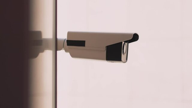 On white background security camera moving recording outside. CCTV surveillance. Privacy, urban, protection, house, system, control, secure, view, safe, video. Slow motion