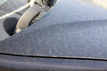 Image of a car body stained by yellow sand
